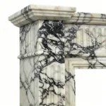 Close-up of a fireplace pillar showcasing black-and-white marble patterns with intricate grooved design.