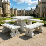 Ornate marble dining table with intricate carving and matching benches placed in a stately castle courtyard under sunny skies.