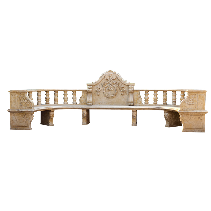 A large, intricately carved marble bench with decorative floral motifs and a central crest design in a light stone hue.