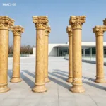 Outdoor arrangement of elegant golden marble columns with intricate floral designs in a modern plaza under clear skies.