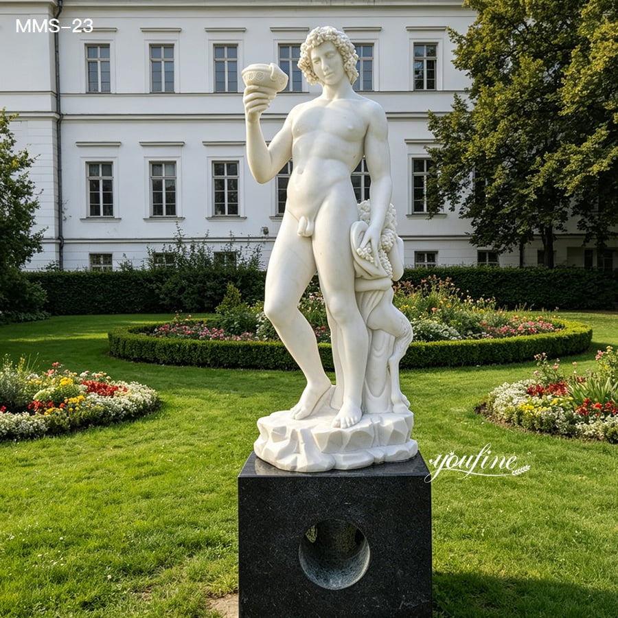 Elegant white marble statue of Bacchus holding a cup, set on a dark pedestal in a lush, flowered garden with a classical building.