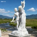 Elegant white marble sculpture depicting two human figures beautifully carved, placed outdoors alongside a serene river and mountains.