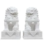 Pair of intricately carved white marble foo dog statues on ornate bases, symbolizing protection and prestige.