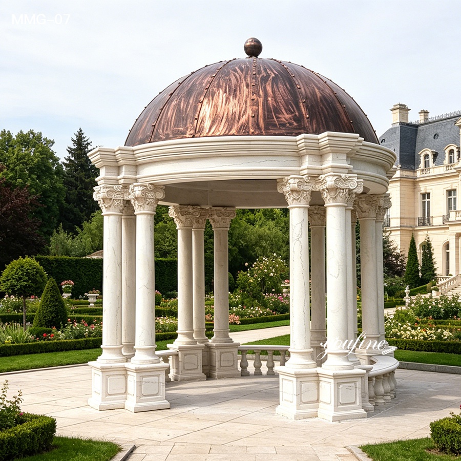 Marble gazebo with decorative columns and a copper dome set in a manicured garden with a mansion in the background.