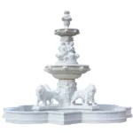White marble tiered fountain featuring intricate carvings, seated figures, and lion sculptures as part of the base design.