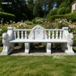 Elegant white marble bench with intricate lion carvings, flanked by lush garden blooms and greenery in a serene outdoor setting.