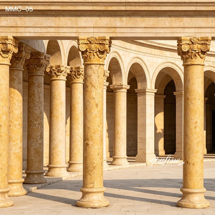 Elegant marble columns with carved capitals arranged in a classical architectural style, bathed in warm sunlight.