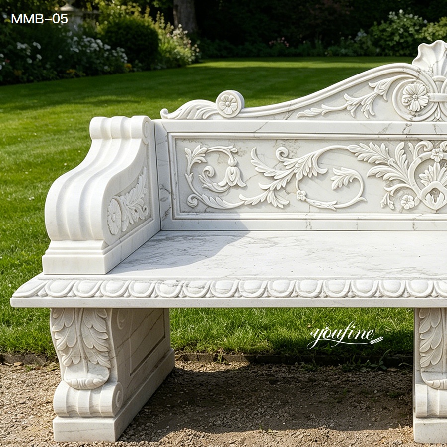Elegant marble garden bench featuring intricate floral carvings and detailed design, set in a lush garden setting.