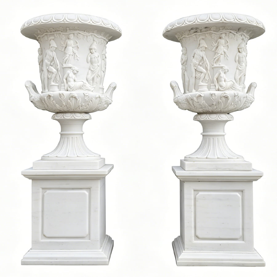 Pair of white marble planters with intricate classical figure carvings on pedestals, showcasing decorative artistry.
