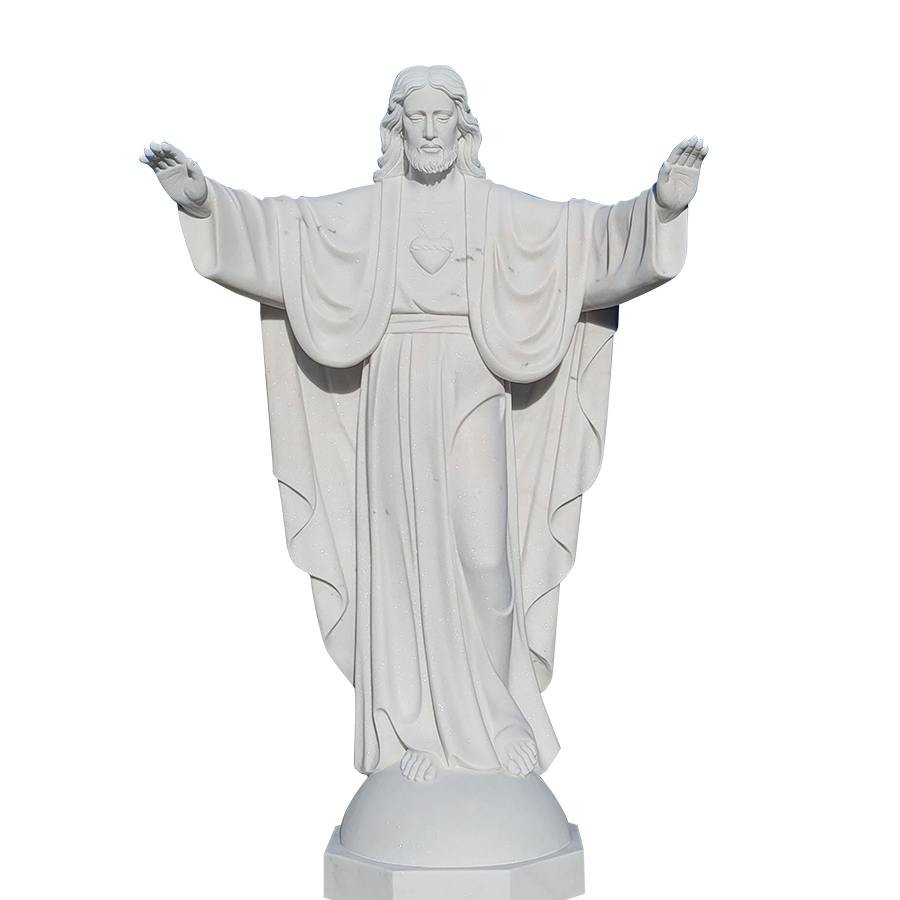 A Sacred Heart marble statue depicting a figure with open arms, detailed robe carvings, and heart emblem on the chest.