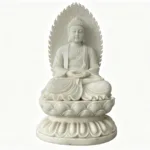 A meticulously carved white marble Buddha statue seated in a lotus position with ornate detailing and a serene aura.