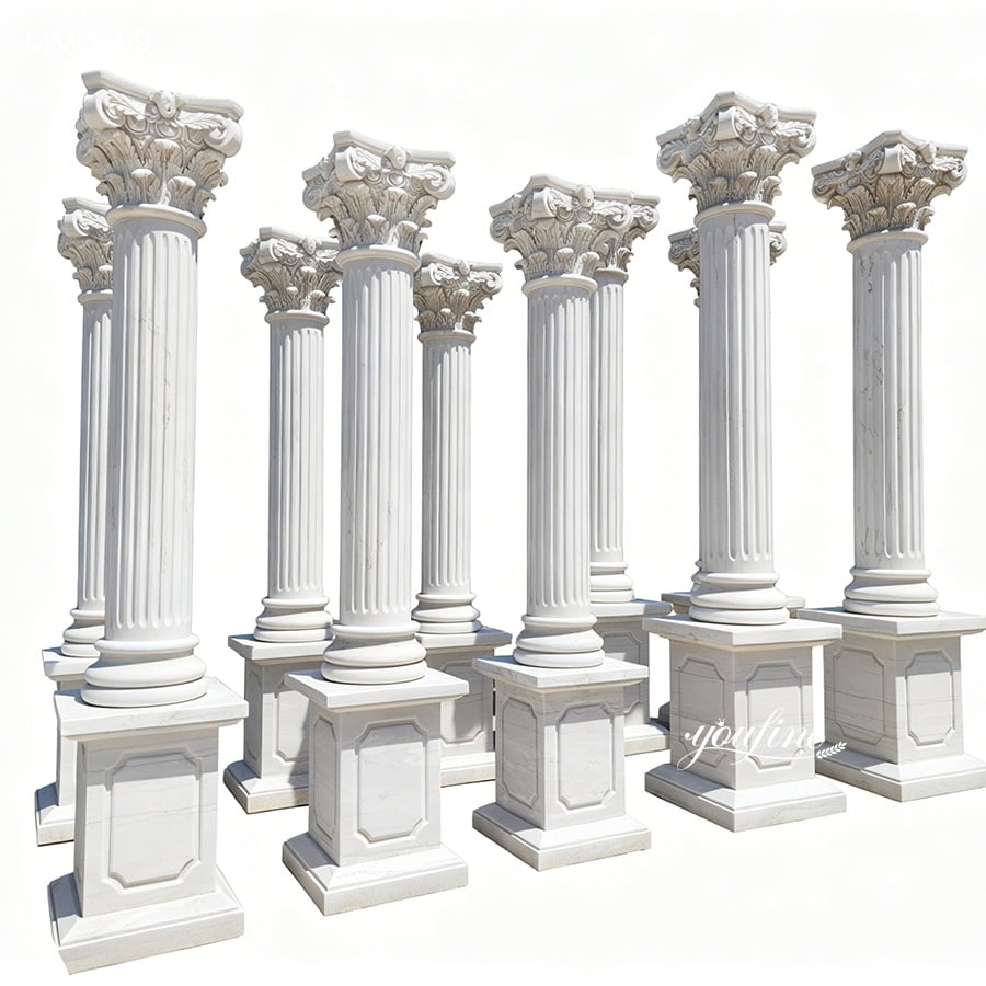 A set of intricately carved white marble Corinthian columns with ornate capitals and strong square bases, arranged in an open area.