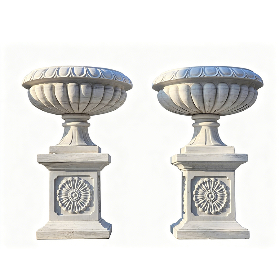 Pair of white marble decorative urns with ornate floral detailing on square pedestals, showcasing elegant craftsmanship.