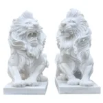 Pair of meticulously carved white marble lion statues, featuring intricate mane details and a commanding presence, on rectangular bases.