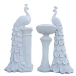 Pair of white marble peacock statues with detailed feathers standing on decorative bases, showcasing craftsmanship.