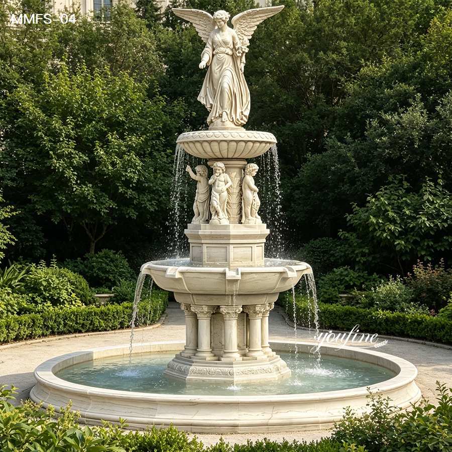 A white marble fountain featuring a winged angel atop tiers with carved figures, surrounded by lush green garden landscaping.