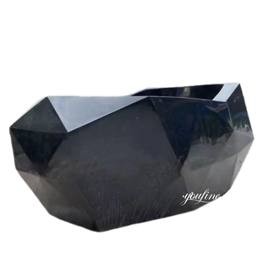 A sleek black marble bathtub with a geometric design featuring sharp angles and smooth polished surfaces, ideal for modern luxury interiors.