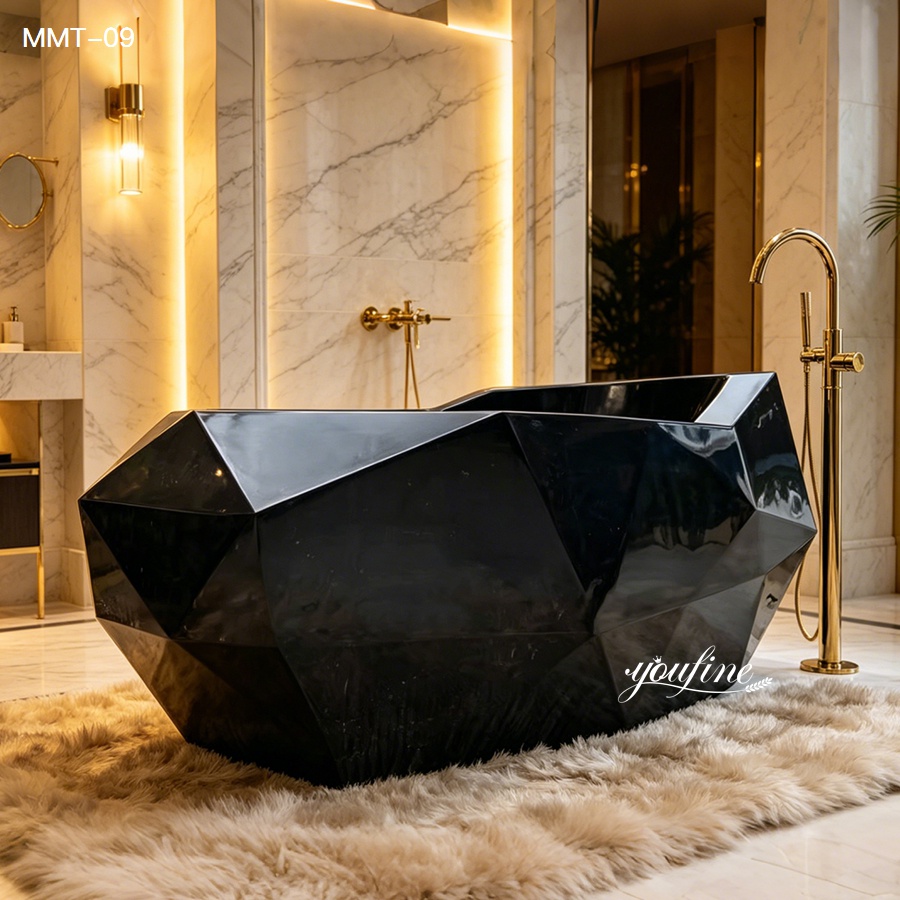 A modern black marble bathtub with a geometric design placed in a luxurious bathroom with marble walls, gold fixtures, and warm lighting.