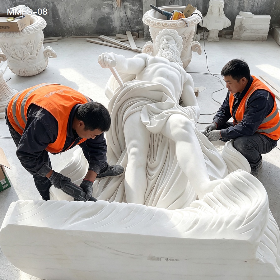 Two craftsmen in orange safety vests work on carving an intricate white marble sculpture depicting a reclining figure in a studio.