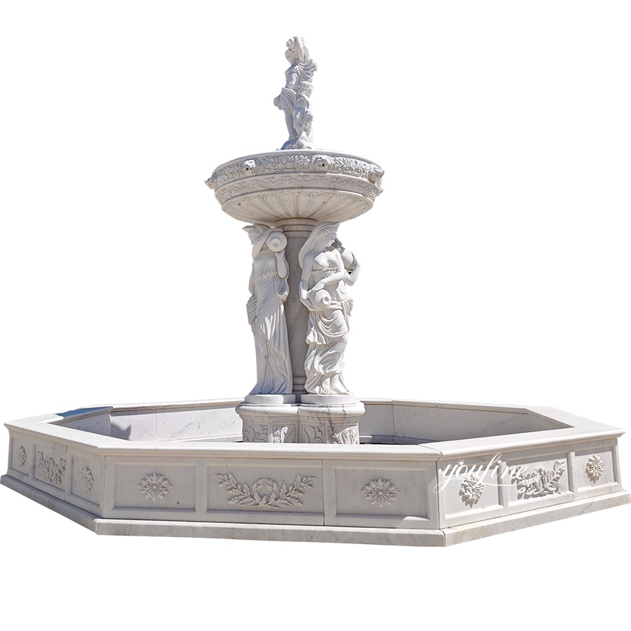 A luxurious white marble tiered fountain featuring detailed female sculptures and floral carvings on its octagonal base.