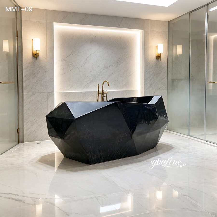 A luxurious black marble bathtub with a faceted design in a modern bathroom featuring white marble walls, gold fixtures, and soft lighting.