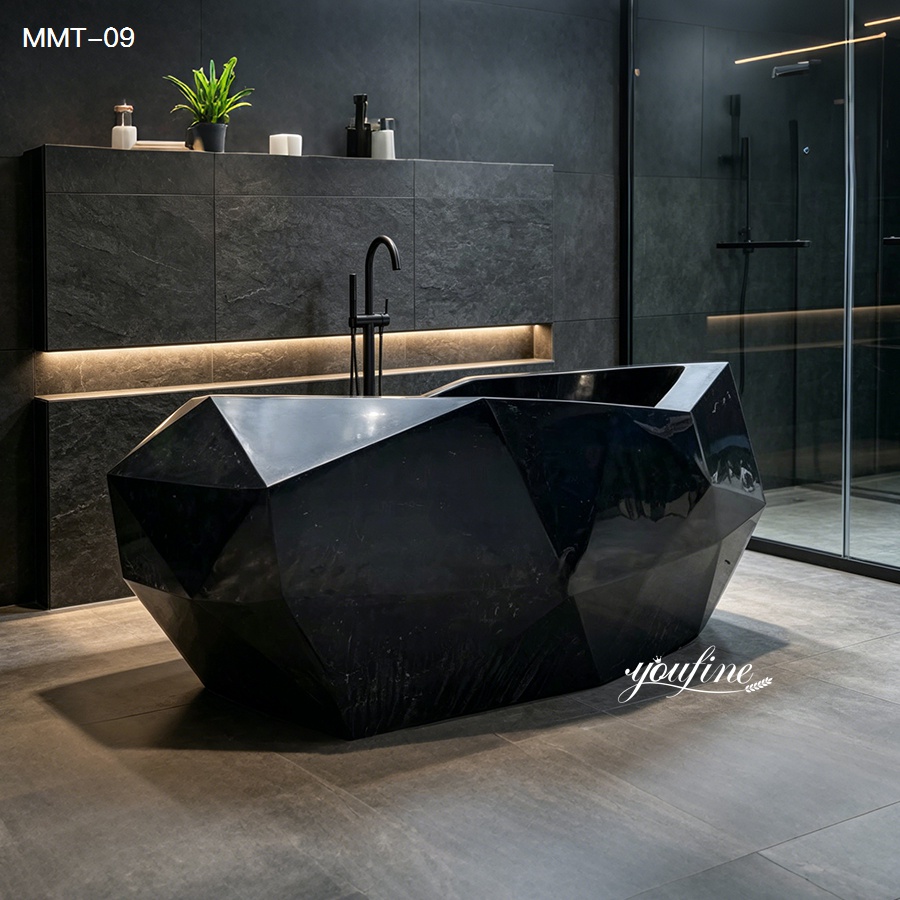 Black geometric marble bathtub in a sleek, modern bathroom with dark stone walls, illuminated shelves, and glass shower door.