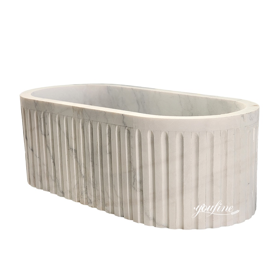 Elegant white marble bathtub featuring a fluted exterior design and a smooth interior, ideal for luxurious bathrooms.