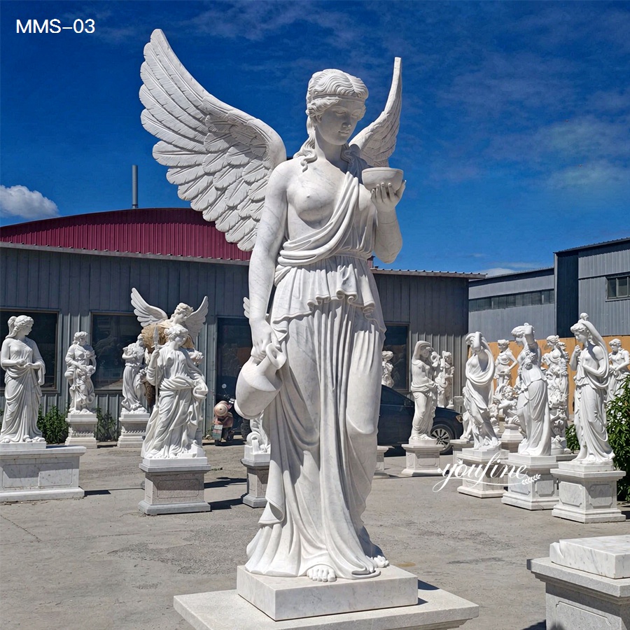 A detailed marble angel sculpture holding a bowl and jug, surrounded by various other marble sculptures in an outdoor display area with a blue sky background.