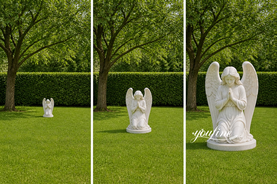 A white marble statue of a praying angel with carved wings placed on a lush green lawn surrounded by hedges and trees.