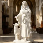 A detailed white marble sculpture of Jesus holding a lamb while another lamb sits by His feet in a tranquil church environment.