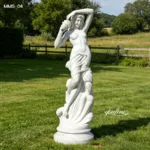A finely detailed marble statue of a female figure holding a seashell, surrounded by natural elements, displayed in a lush garden.