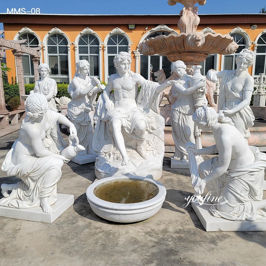 Group of intricately carved white marble sculptures featuring human figures in an outdoor setting around a central fountain.