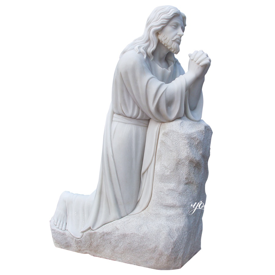 Elegant marble sculpture of Jesus Christ kneeling on a rock with hands clasped in prayer, showcasing serene craftsmanship.